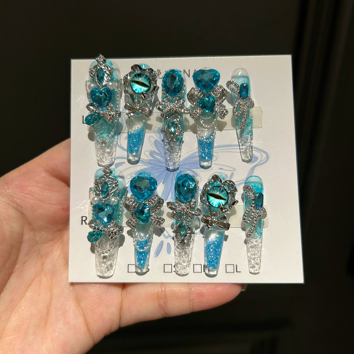 Handmade press-on nails: blue quicksand, elegant, luxurious, heavily detailed, whitening, and seductive