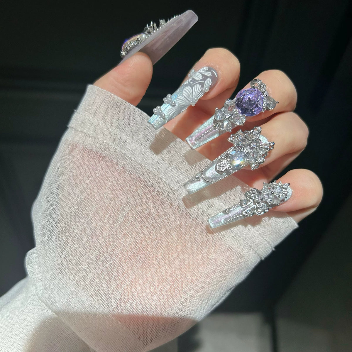 Hand-painted, long press-on nails featuring embroidery-style designs, color-blocking, and a cat-eye effect—entirely handmade.